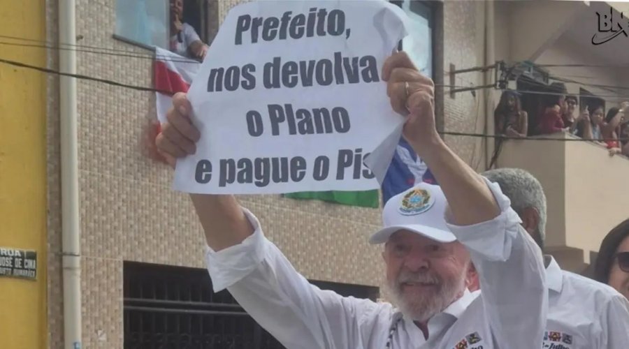 [Lula ergue cartaz em protesto contra gestão municipal durante cortejo do 2 de Julho]